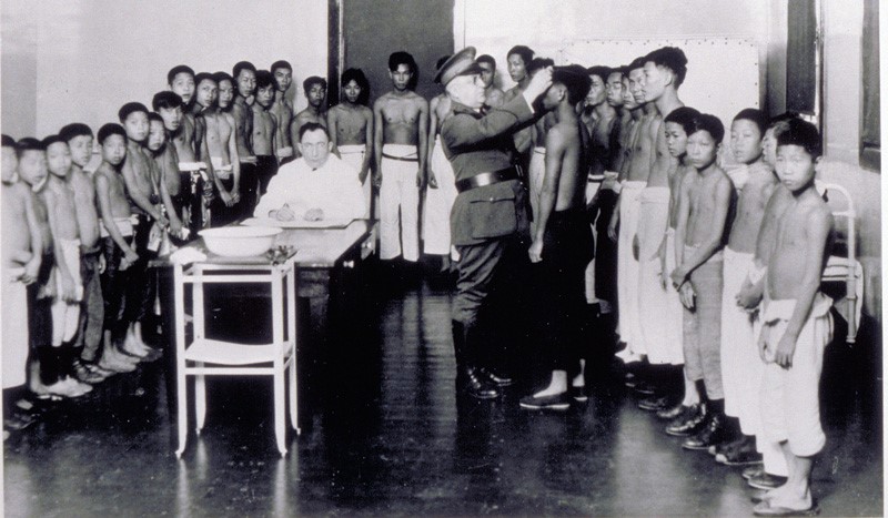 South Pacific immigrants being examined by a doctor at Ellis Island, circa 1910.